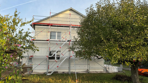 Haus mit Gerüst an dessen Fassade Löcher gebohrt wurden, um Sonals-Panels an der Fassade anzubringen