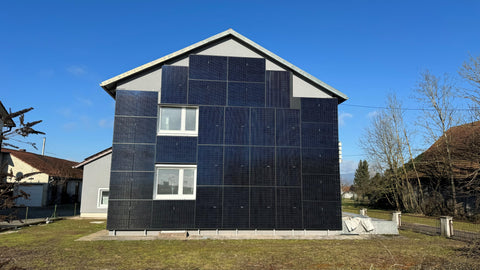 Haus an dessen Fassade Solar Panels befestigt wurde